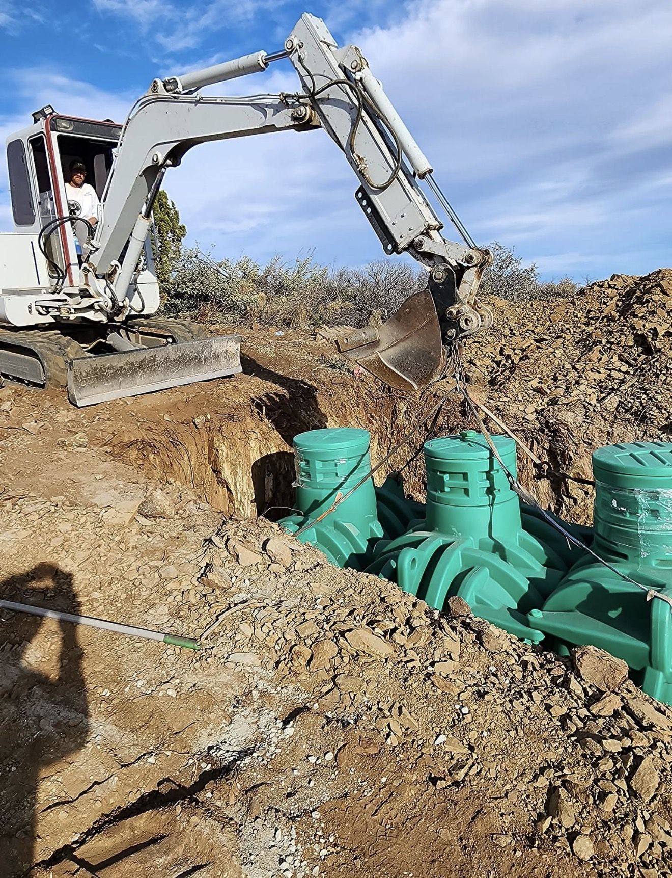 Setting green septic tanks with a compact excavator